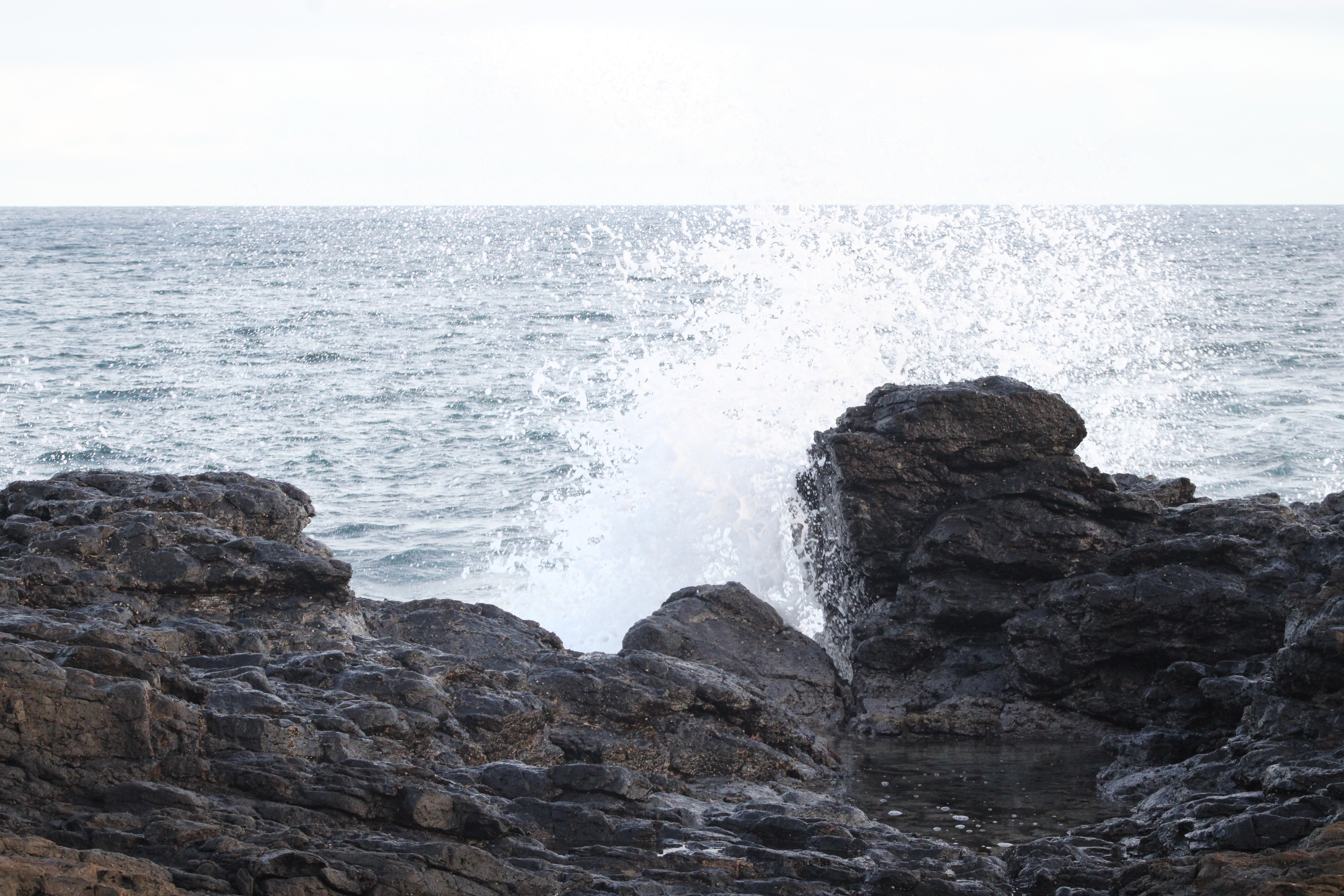 Waves crashing against lava rock